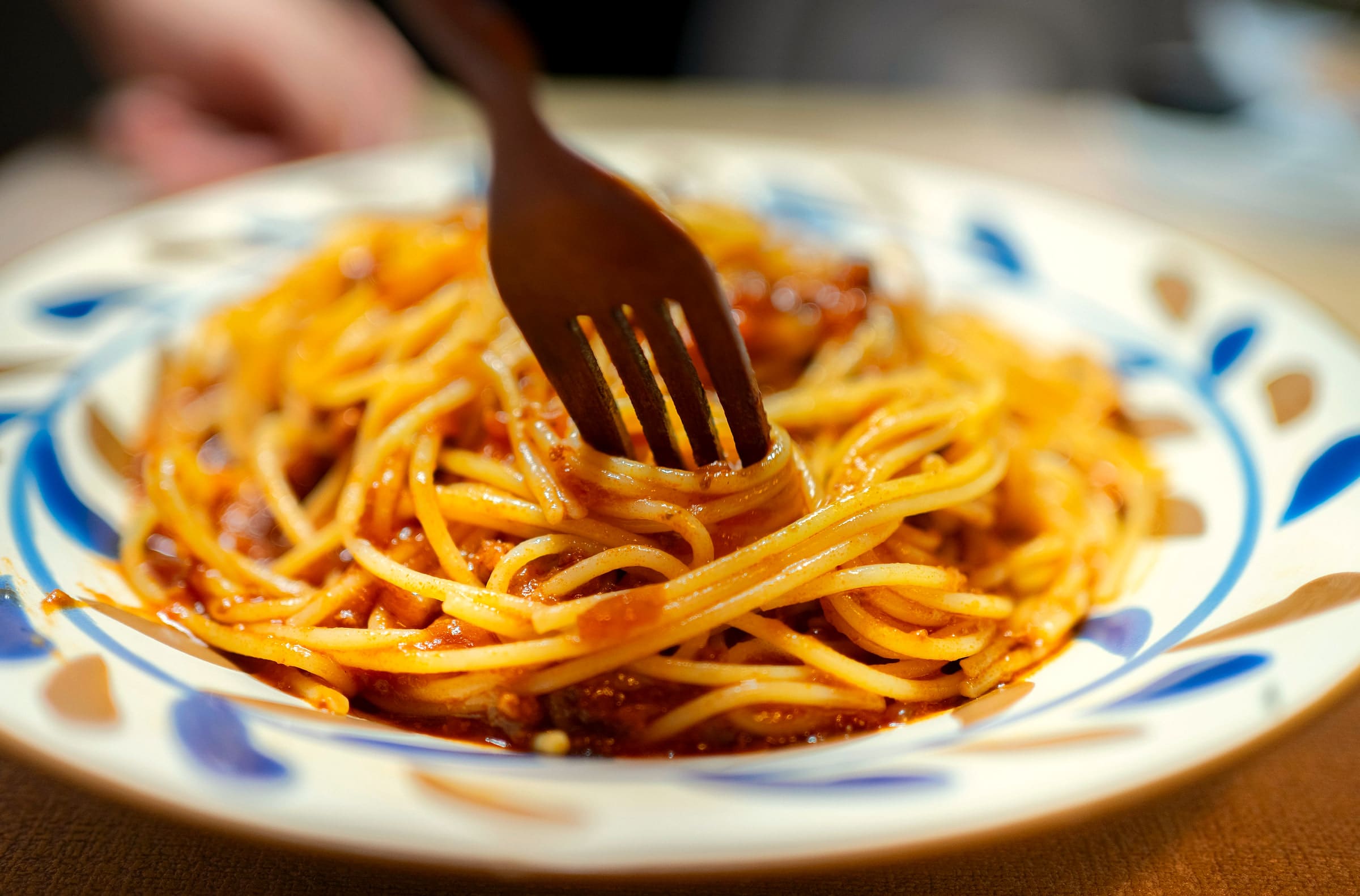 Spaghetti mit Tomatensauce werden auf die Gabel gedreht